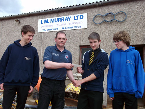 Ali Baco MacLean is pictured handing a cheque over to Connor MacLean